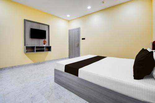 a bedroom with a bed and a flat screen tv at Super Townhouse Taramandal Near Sahara States in Bhauvāpār