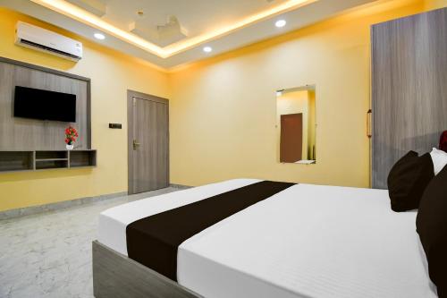 a bedroom with a bed and a flat screen tv at Super Townhouse Taramandal Near Sahara States in Bhauvāpār