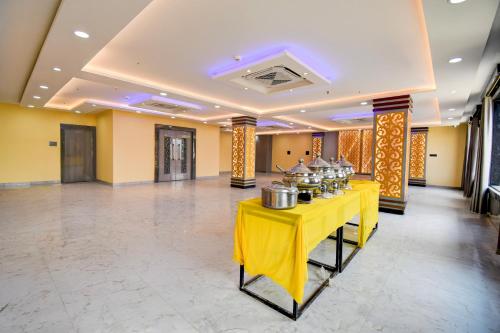a banquet hall with a yellow table with pots on it at Super Townhouse Taramandal Near Sahara States in Bhauvāpār