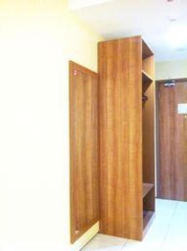a closet with wooden doors in a room at Evora Hotel in Surabaya