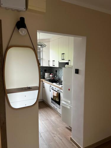 a kitchen with white cabinets and a white refrigerator at ZieloneMistrzejowice in Kraków