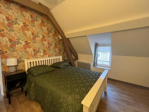 - une chambre avec un lit vert et un papier peint floral dans l'établissement Mer&Campagne Wimille, à Wimille
