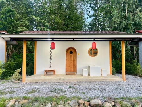 a small house with a front porch with a door at สวนปาล์มการ์เด้นโฮม เชียงคาน Suanpalm Garden Home Changkhan in Chiang Khan