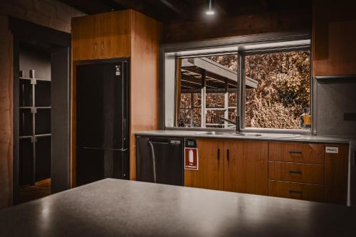 a kitchen with a sink and a window at The Maple Lodge with Alpacas, Goats, Boars, Ducks & Chickens Farm Stay with Outdoor Pizza Oven in Robertson