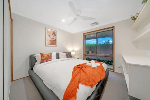 Kenny HillSunny Pool Access Home for Family的一间卧室配有一张带橙色毯子的床