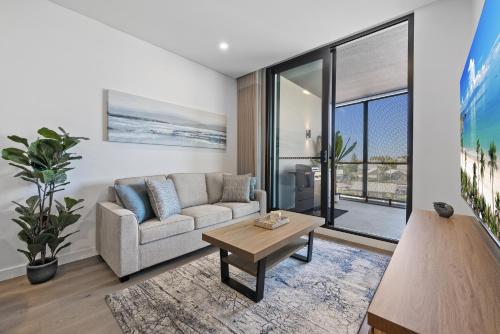 North FremantleにあるCharming 1-Bed with Rooftop Access & Parkingのソファとテーブルのあるリビングルーム