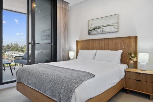 Un dormitorio con una cama grande y un balcón. en Charming 1-Bed with Rooftop Access & Parking, en North Fremantle