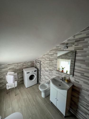a bathroom with a sink toilet and a washing machine at beb Dragonara in Torremaggiore