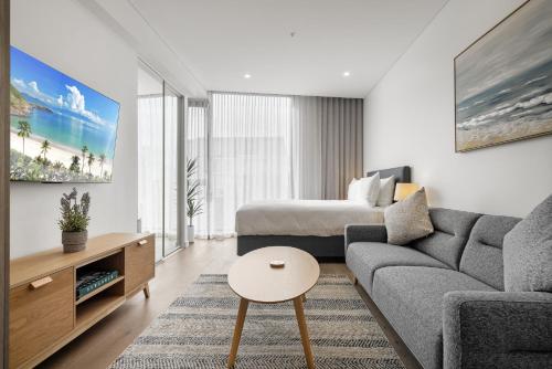 a living room with a couch and a bed at Chic Studio Stay Near Cafés and Coastline in North Fremantle