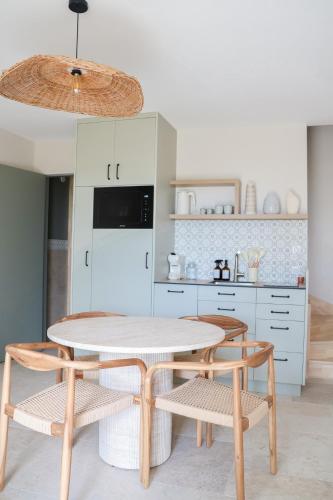 une cuisine avec une table, des chaises et un réfrigérateur dans l'établissement Les Gites de Princé, à Saint-Mélaine-sur-Aubance