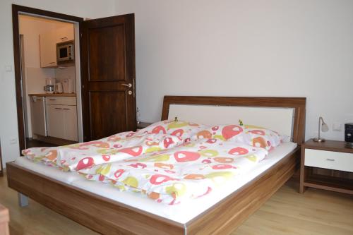 a bedroom with a bed and a kitchen with a microwave at Appartements Bürger in Krumpendorf am Wörthersee