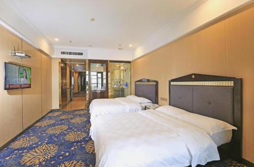 a hotel room with three beds in it at Zhongshan Hui Quan Hotel in Zhongshan