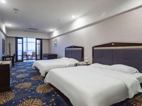 a hotel room with three beds in a room at Zhongshan Hui Quan Hotel in Zhongshan