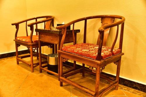 two wooden chairs sitting next to each other at Zhongshan Hui Quan Hotel in Zhongshan