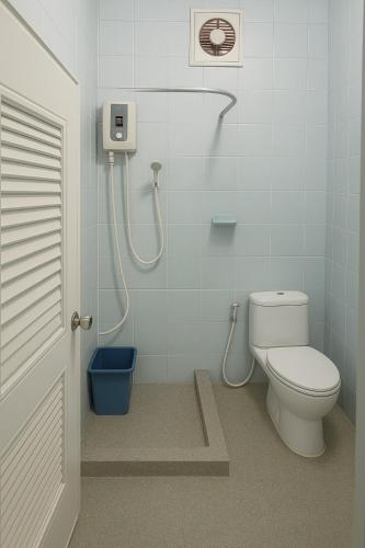 a bathroom with a toilet and a shower at Baan Pa Dee Si Sa Ket in Ban Dong Bang