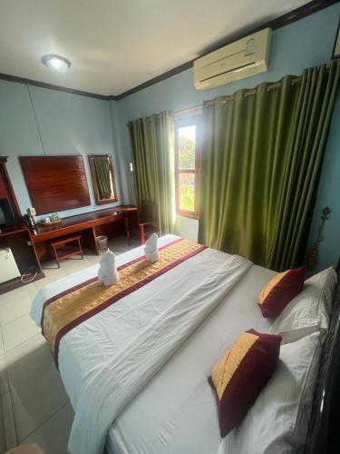 a large bed in a room with a window at Vang Vieng Khampaseuth Hotel in Vang Vieng