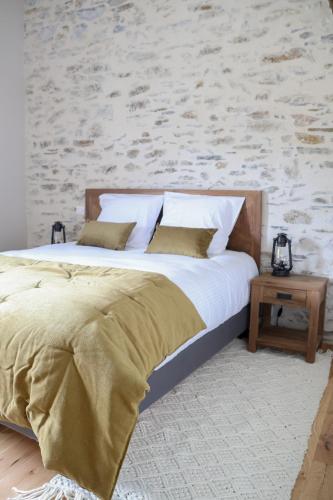 une chambre avec un lit et un mur avec une brique dans l'établissement Les Gites de Princé, à Saint-Mélaine-sur-Aubance