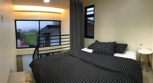 a bedroom with a bed and a large window at Compound holiday home - 1 bedroom - Backyard Loft in Wonosobo