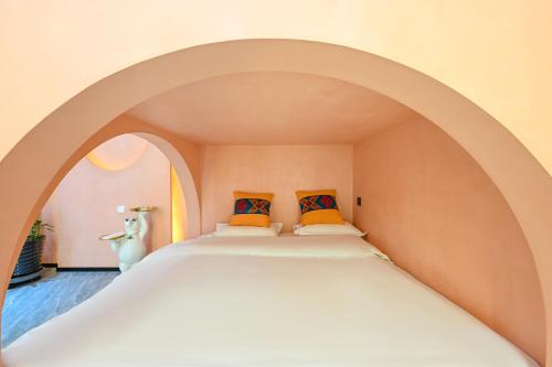 a bed in an archway with two pillows at Hidden Lodge Xiaoyin B&B in Xizhuang