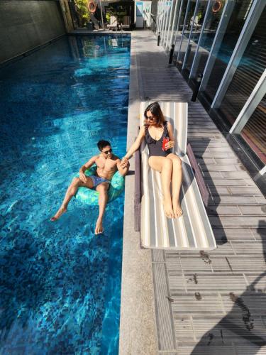 a man and a woman sitting in a swimming pool at Marriott Suites Pune in Pune
