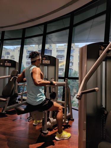 a man sitting on a treadmill in a gym at Marriott Suites Pune in Pune