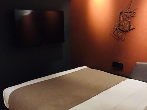 a bedroom with a bed and a flat screen tv at YUNIK-Shanghai Zhongshan Park Yan'an Xi Road in Shanghai