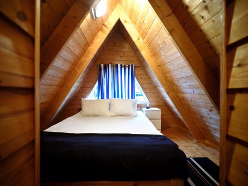 a bedroom with a bed in a attic at Mholiday Sarbinowo u Kaspra in Sarbinowo