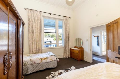 里夫顿Haere Mai Reefton Heritage Holiday Home的有两张床和一扇窗户的卧室