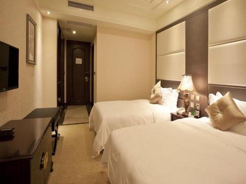 a hotel room with two beds and a television at Chengdu Haotian Guotai Hotel in Chengdu
