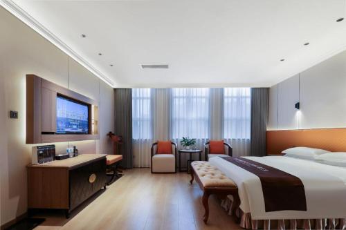 a hotel room with a large bed and a desk at Chengdu Haotian Guotai Hotel in Chengdu