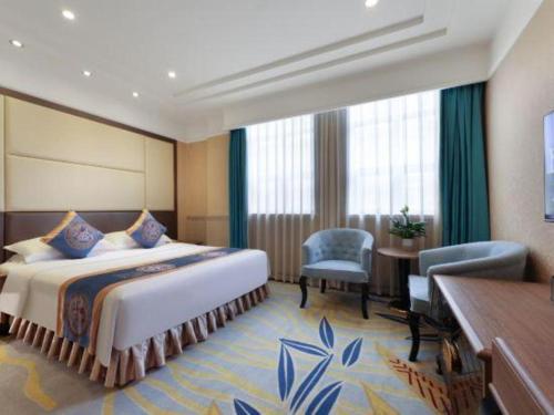a hotel room with a bed and a table and chairs at Chengdu Haotian Guotai Hotel in Chengdu