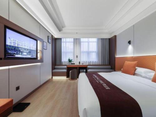a hotel room with a large bed and a flat screen tv at Chengdu Haotian Guotai Hotel in Chengdu