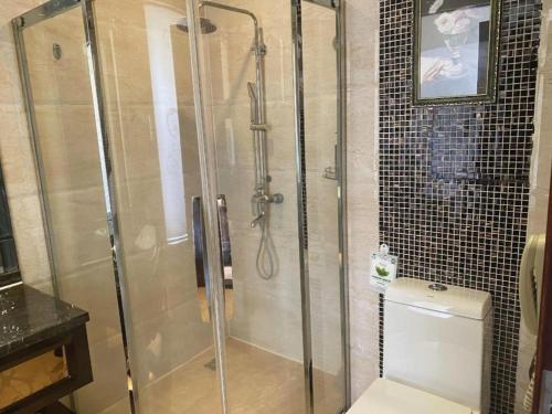 a shower with a glass door in a bathroom at Chengdu Haotian Guotai Hotel in Chengdu