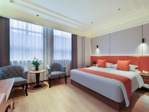 a bedroom with a large bed and two chairs at Chengdu Haotian Guotai Hotel in Chengdu