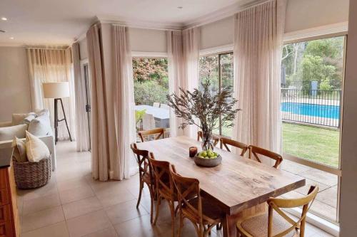 a dining room with a wooden table and chairs at Westbrook, Kangaroo Valley in Kangaroo Valley