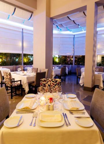 a dining room with white tables and chairs at Crowne Plaza Lima by IHG in Lima