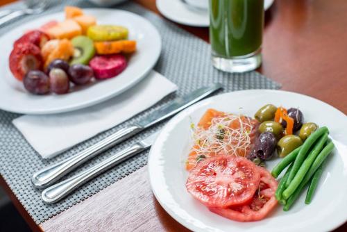 two plates of food on a table with vegetables at Crowne Plaza Lima by IHG in Lima