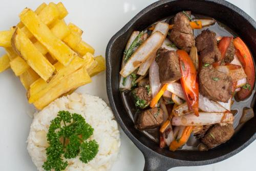 a pan of food with meat and vegetables and french fries at Crowne Plaza Lima by IHG in Lima