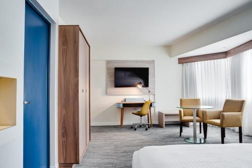 a hotel room with a bed and a table and chairs at Crowne Plaza Lima by IHG in Lima