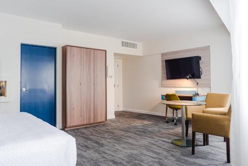 a hotel room with a bed and a desk and a tv at Crowne Plaza Lima by IHG in Lima