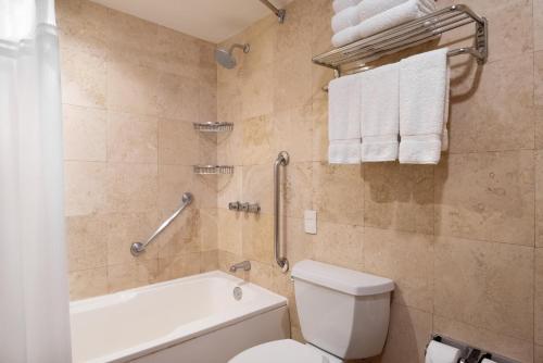 a bathroom with a toilet and a bath tub with towels at Crowne Plaza Lima by IHG in Lima