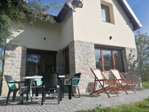eine Terrasse mit Stühlen und Tischen vor einem Gebäude in der Unterkunft Pelister Riverside Villa in Bitola