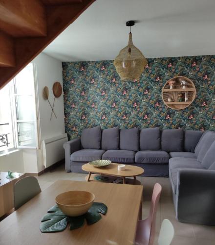 un salon avec un canapé bleu et une table dans l'établissement Superbe duplex « le Grévy », à Dole