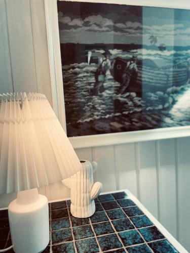 a lamp sitting on a table next to a painting at Charming rooftop apartment in Uhre in Brande