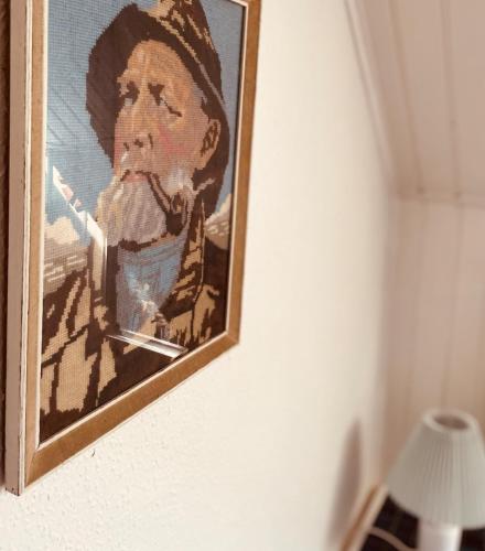 a painting of a man hanging on a wall at Charming rooftop apartment in Uhre in Brande