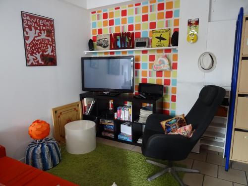 un salon avec une chaise et une télévision dans l'établissement h2oholidays, à Capbreton