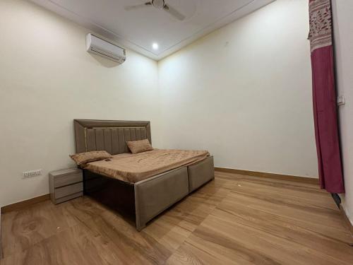 a bedroom with a bed in the corner of a room at Gulati farm in Bhundsi