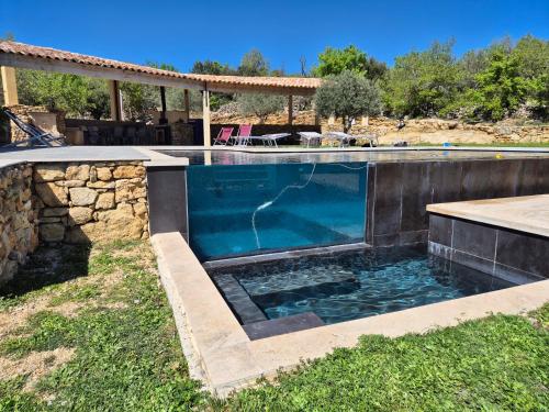 - une piscine dans une cour dotée d'un mur en pierre dans l'établissement Lou damisello - Villa moderne, à Viens