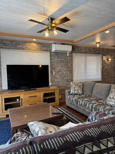 a living room with a couch and a flat screen tv at ヴィラ マイラニハウス沖縄 in Hamakawa