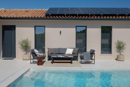 a patio with a couch and chairs next to a pool at Villa TonKa with jacuzzi sauna and private pool in Labin